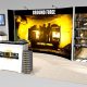 The IM2 trade show exhibit display is a10 x 20 inline and provides product shelving, and a flat screen work station with plenty of writing space. The backlit back wall counter with a large mural graphic, reception counter with space for writing and plenty of storage.  View 2