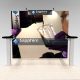 Dual panel HER10 exhibit design with two arms with counter top writing space. The split mural wall features your main message placed on the front face of the wall and beside it on the right. Add custom elements like counters or storage. View 1